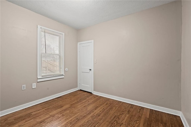 spare room with hardwood / wood-style floors and a textured ceiling