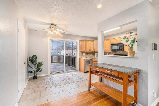 kitchen featuring a textured ceiling, light brown cabinets, stainless steel dishwasher, ceiling fan, and decorative backsplash