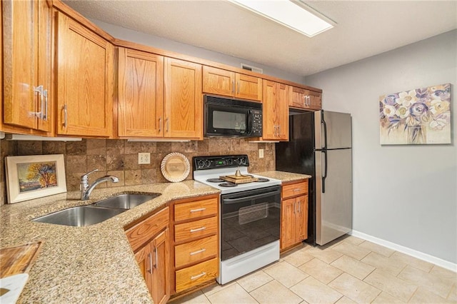 kitchen featuring sink, stainless steel refrigerator, electric range, light stone countertops, and decorative backsplash