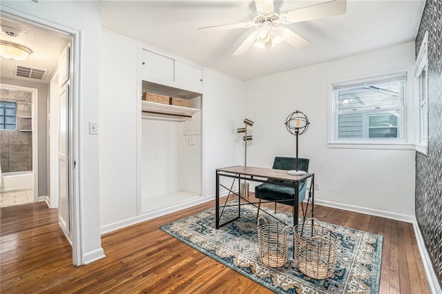 office area with a healthy amount of sunlight, dark wood-type flooring, and ceiling fan