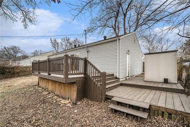 rear view of house with a wooden deck and a storage unit