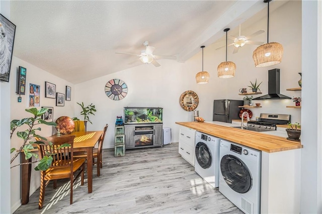 clothes washing area featuring ceiling fan, light hardwood / wood-style flooring, sink, and washing machine and clothes dryer