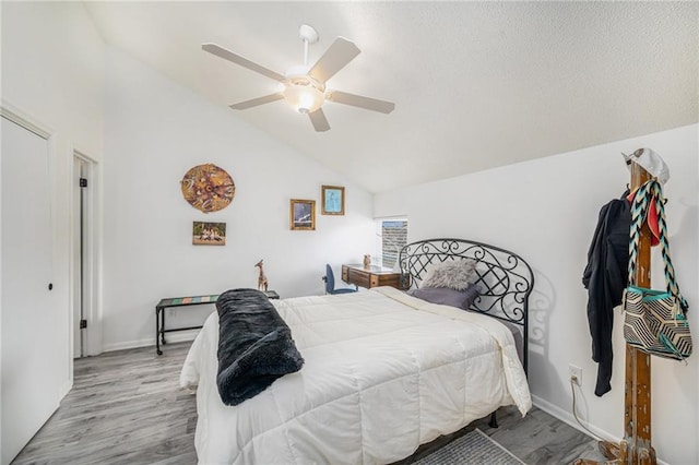 bedroom with ceiling fan, lofted ceiling, and light wood-type flooring