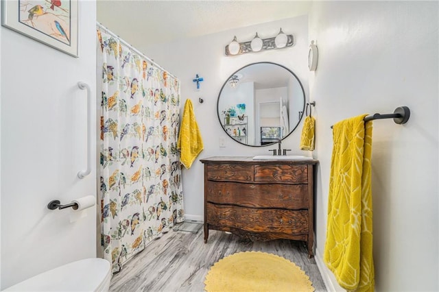 bathroom featuring vanity, hardwood / wood-style floors, a shower with curtain, and toilet