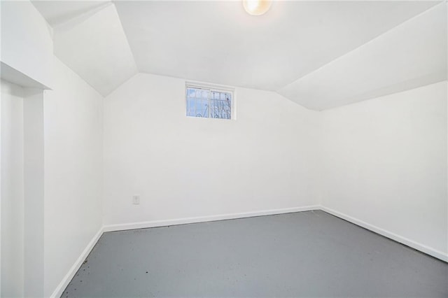 bonus room with concrete flooring and vaulted ceiling