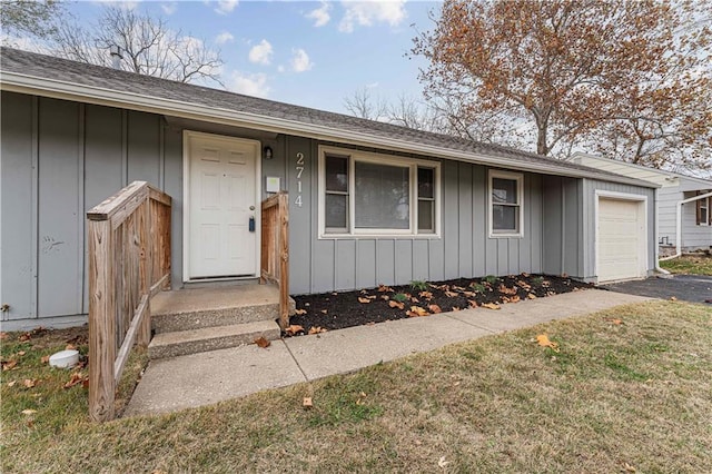 property entrance with a garage and a yard