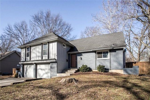 split level home with a garage, brick siding, driveway, and a shingled roof