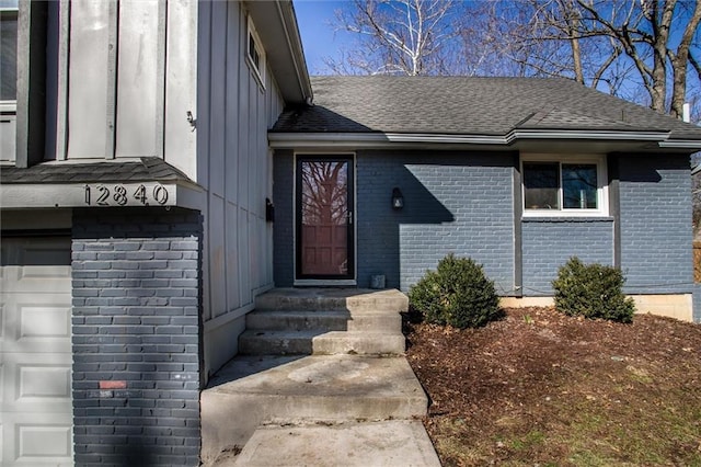 property entrance with brick siding, board and batten siding, and a shingled roof