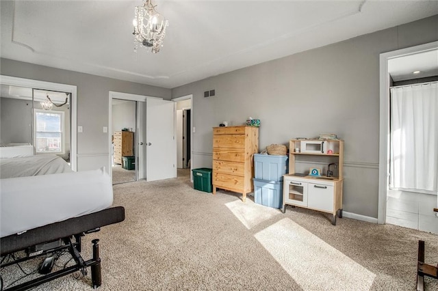 bedroom featuring visible vents, light carpet, an inviting chandelier, and multiple closets