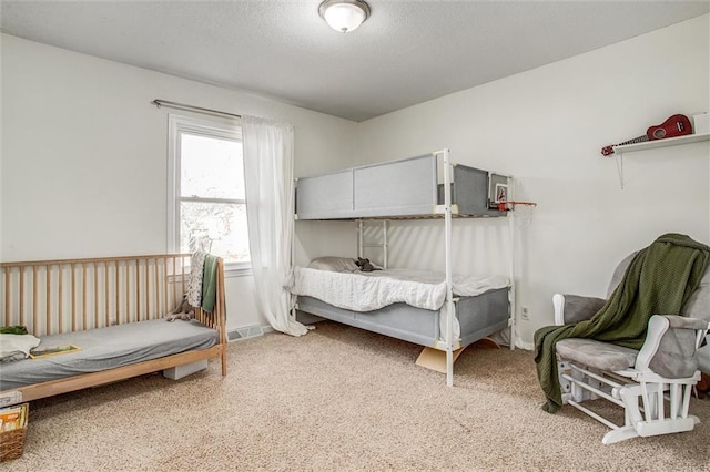 carpeted bedroom with baseboards and a textured ceiling