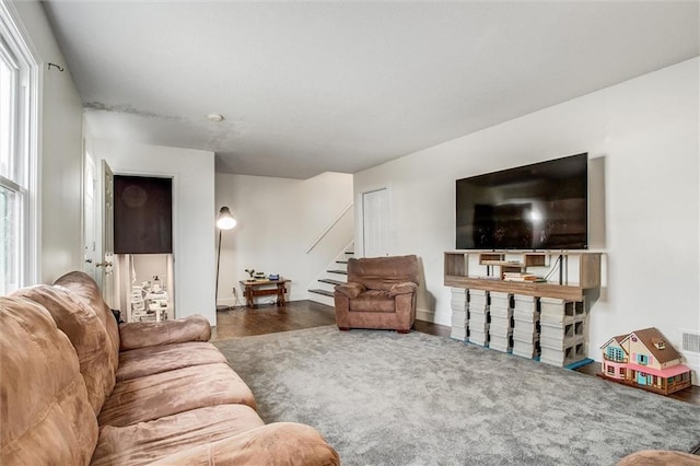 living area with stairs and wood finished floors