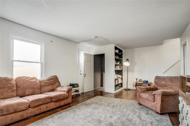 living area with a textured ceiling and dark wood-style flooring