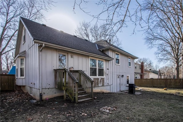 view of front of house featuring fence, board and batten siding, and a shingled roof