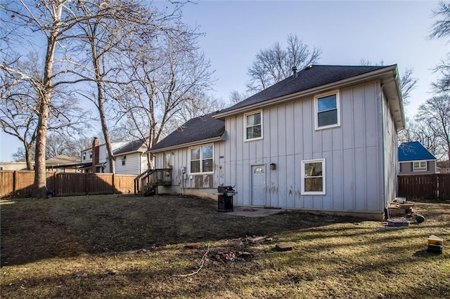 back of house with fence and board and batten siding