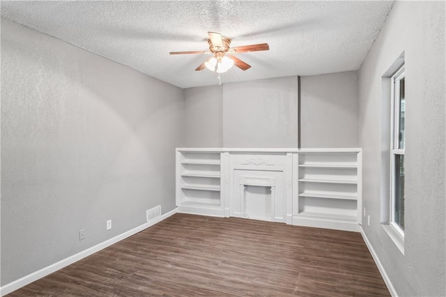 unfurnished living room featuring ceiling fan, dark wood-type flooring, a textured ceiling, and a fireplace