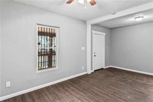 empty room featuring ceiling fan, dark hardwood / wood-style floors, and a textured ceiling