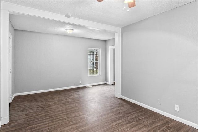 spare room featuring a textured ceiling, dark hardwood / wood-style floors, and ceiling fan