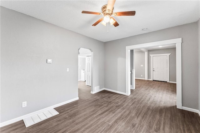 empty room featuring dark wood-type flooring and ceiling fan