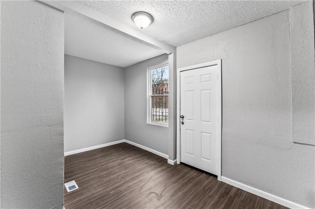 foyer with dark hardwood / wood-style floors and a textured ceiling