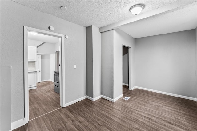 unfurnished room with dark hardwood / wood-style floors and a textured ceiling