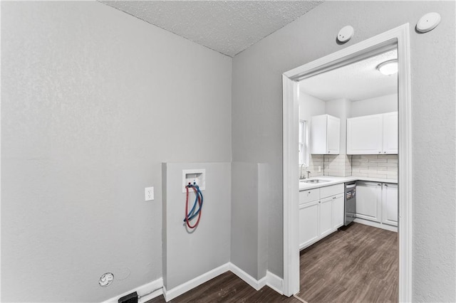 laundry room with sink, dark hardwood / wood-style floors, washer hookup, and a textured ceiling