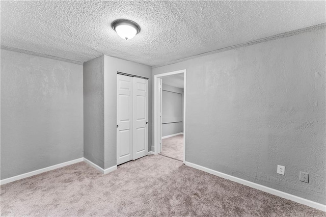 unfurnished bedroom with light colored carpet, a textured ceiling, and a closet