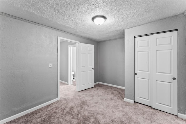 unfurnished bedroom featuring light colored carpet, a closet, and a textured ceiling