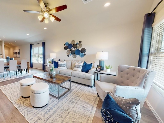 living room with light hardwood / wood-style floors and ceiling fan