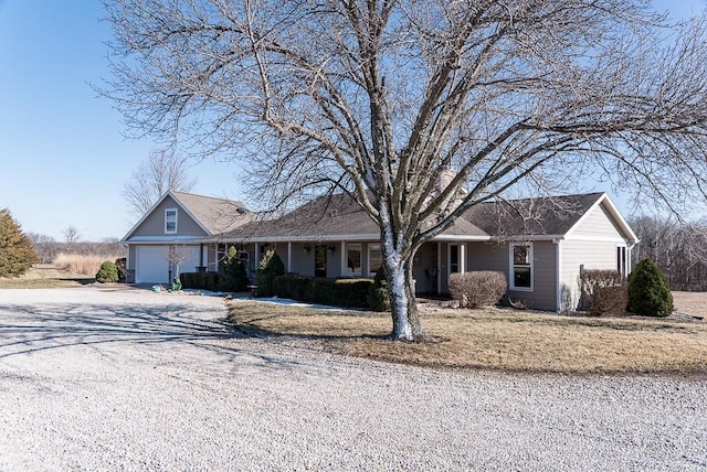 ranch-style house with gravel driveway and a garage