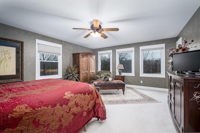 bedroom featuring baseboards, light carpet, and ceiling fan