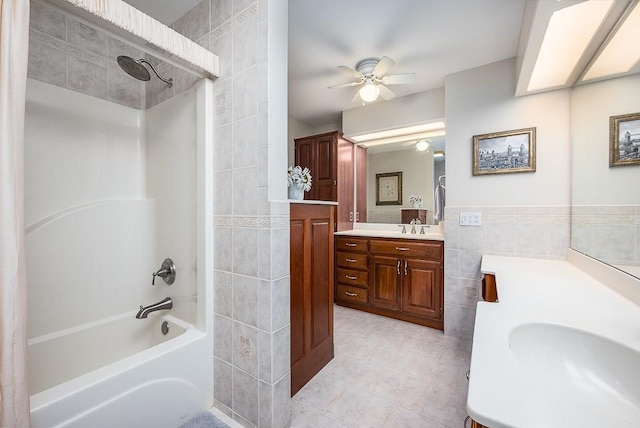 bathroom with tile patterned flooring, tile walls, ceiling fan, shower / bathing tub combination, and vanity