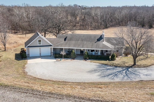 view of front of house featuring covered porch, driveway, and a garage