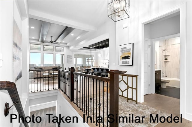 hall with recessed lighting, beam ceiling, a notable chandelier, and an upstairs landing