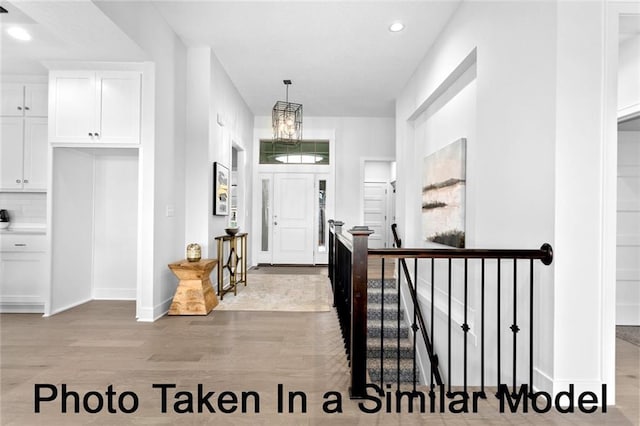 entryway with light wood-type flooring, baseboards, and recessed lighting