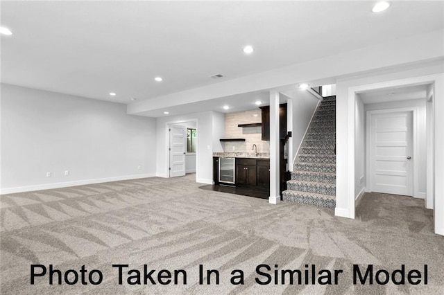 living room featuring beverage cooler, light colored carpet, stairs, indoor wet bar, and recessed lighting