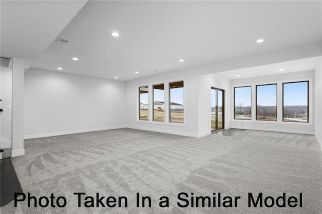 unfurnished living room with carpet floors, recessed lighting, visible vents, and baseboards