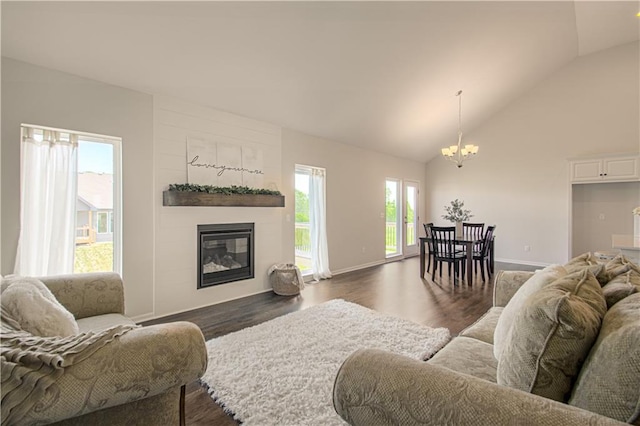 living room with a large fireplace, dark hardwood / wood-style flooring, high vaulted ceiling, and a notable chandelier