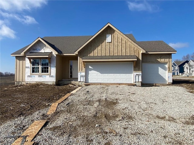 view of front of property with board and batten siding, driveway, a shingled roof, and an attached garage