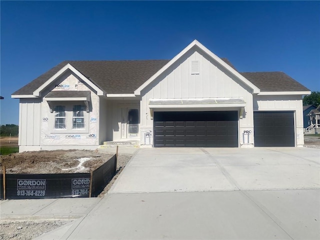 1102 Noah Ln, Kearney, MO 64060 - view of front of house featuring a garage, board and batten siding, driveway, and roof with shingles