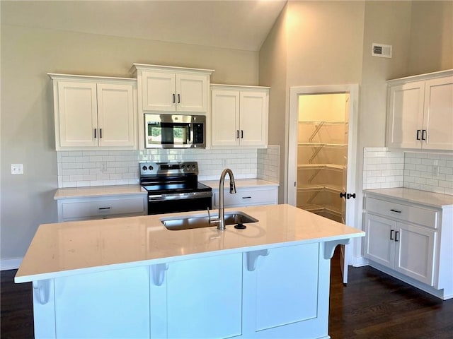 1102 Noah Ln, Kearney, MO 64060 - kitchen with stainless steel microwave, range with electric stovetop, decorative backsplash, dark wood-style floors, and lofted ceiling