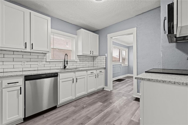 kitchen featuring sink, white cabinetry, appliances with stainless steel finishes, light stone countertops, and light hardwood / wood-style floors