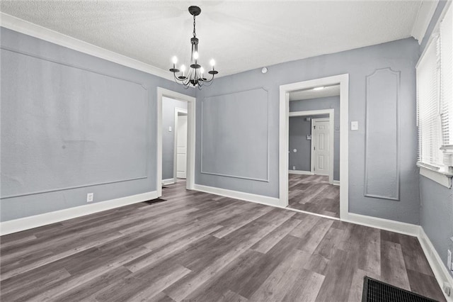 unfurnished dining area with hardwood / wood-style flooring, a textured ceiling, and an inviting chandelier