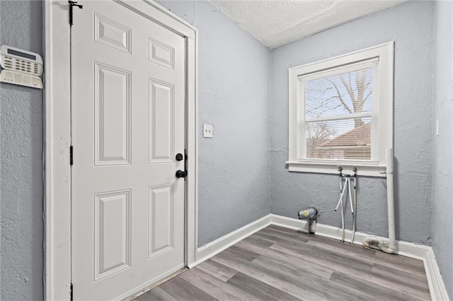 laundry area featuring a textured ceiling and light wood-type flooring