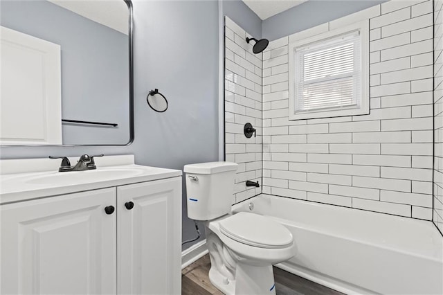 full bathroom with tiled shower / bath, vanity, toilet, and hardwood / wood-style floors