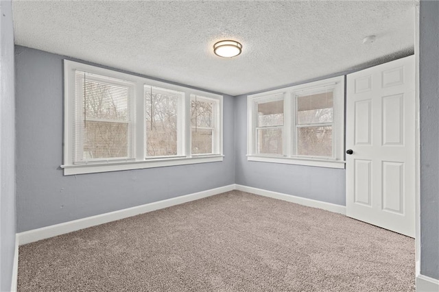 carpeted empty room featuring a textured ceiling