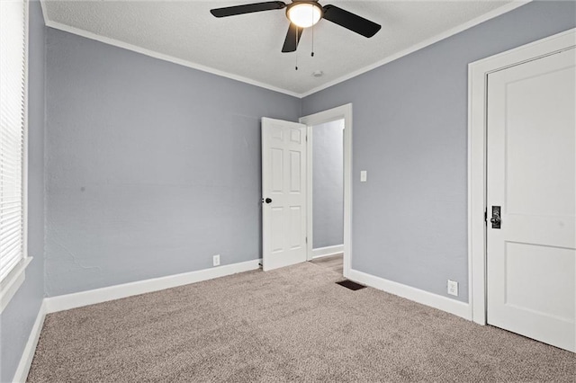 unfurnished room with ornamental molding, ceiling fan, and carpet