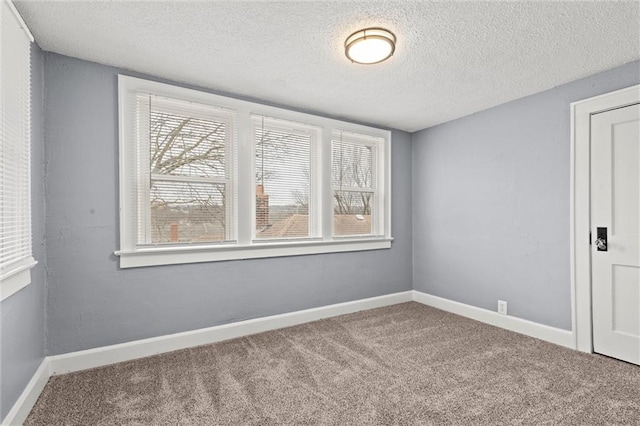 spare room with a textured ceiling and carpet flooring