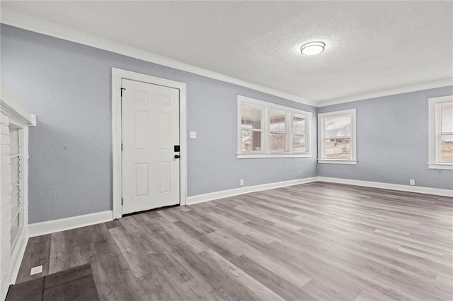 interior space with crown molding, a textured ceiling, and light wood-type flooring