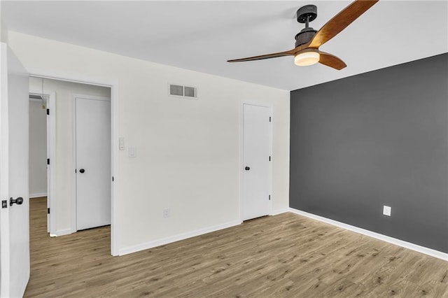 spare room with ceiling fan and light wood-type flooring