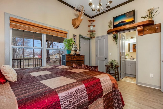 bedroom featuring ensuite bath, sink, a chandelier, crown molding, and light wood-type flooring